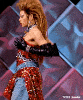 a woman in a red sequined dress and black gloves is dancing on a stage .