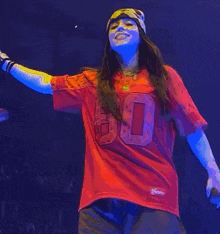 a person wearing a red jersey with the number 8 on it is singing into a microphone