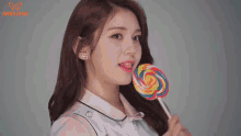 a girl holding a colorful lollipop in her mouth