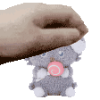 a hand is petting a stuffed animal with a pink swirl in its mouth .