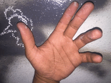 a close up of a person 's hand against a gray background