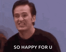a man is smiling and saying `` so happy for u '' while standing in front of a woman .