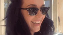 a woman is wearing sunglasses and smiling .
