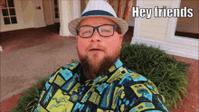 a man with a beard wearing a hat and glasses says hey friends