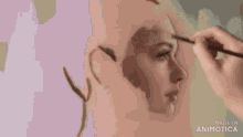 a person is painting a face with a brush .