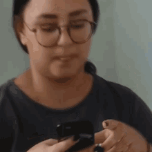 a blurry picture of a woman holding a cell phone and giving the middle finger .