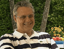 a man wearing glasses and a striped shirt with a lacoste logo on it