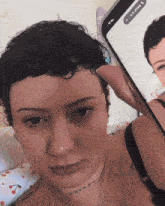 a woman taking a picture of herself with a phone that says ' ua ' on it
