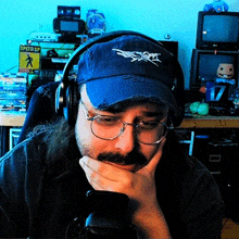 a man wearing headphones and a blue hat has a speed up sign behind him
