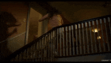 a woman is walking down the stairs in a dark room .