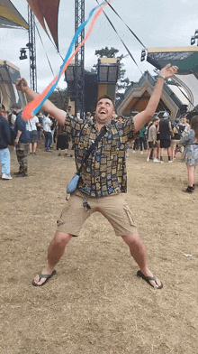 a man in a hawaiian shirt is holding a red and blue ribbon in his hands