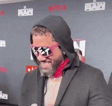 a man wearing a hooded jacket and sunglasses has the word fat on his sunglasses
