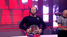 a man in a wrestling ring holding a trophy with the word impact in the background