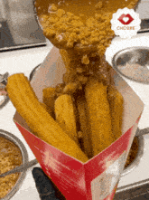 churros are being poured into a box with choore written on the bottom