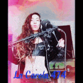a woman singing into a microphone with the name la carola 474 on the bottom right