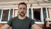 a man with a beard is standing in front of a room with money flying in the air