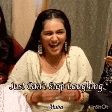 a woman is laughing while sitting on a couch .