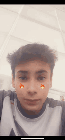 a young boy with freckles on his face is wearing a grey shirt