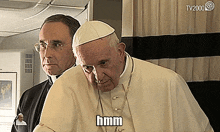 a man in a white robe has the word hmm on his shirt