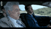 three men are sitting in a car with arte written on the bottom