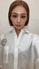 a woman is wearing a white shirt with a face on the pocket