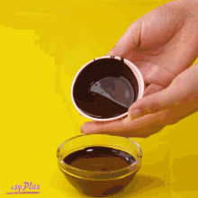 a person is pouring chocolate into a glass bowl with a yellow background and the words j-plus on the bottom