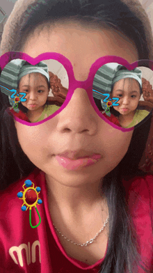 a little girl wearing heart shaped sunglasses with a sticker that says zzz on it