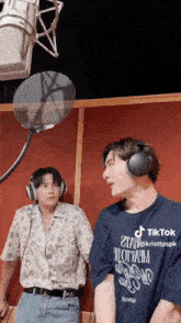 two men wearing headphones and a shirt that says tik tok