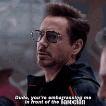 a man wearing sunglasses is talking to another man while wearing a black jacket .