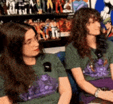 two women are sitting next to each other in front of a display of action figures