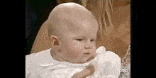 a woman is holding a baby in her arms .