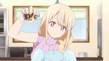 a girl in a purple sweater is holding a purple bottle in her hand