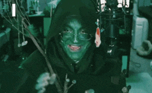 a person with green paint on their face says " i am meticulous " in front of a microphone