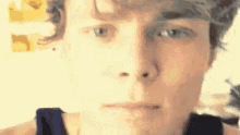 a close up of a young man 's face with a slight smile on his face .
