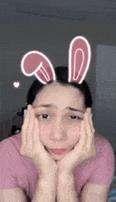 a woman with bunny ears on her head is making a face
