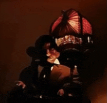 a man in a suit and tie is standing in front of a lamp .