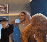 a woman with pink hair is sitting next to a man and a dog