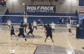 a volleyball game is underway with a banner that says wolf pack fans family