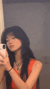 a woman is taking a picture of herself in a mirror .