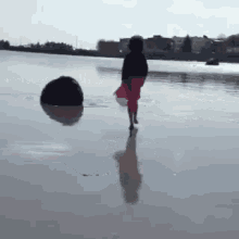 a woman in a red skirt walks on a beach