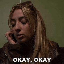 a woman is talking on a cell phone and says okay