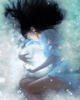 a woman in a blue dress is holding a full moon in her arms