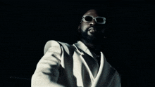 a man wearing sunglasses and a white jacket