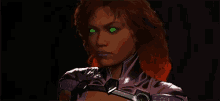 a close up of a woman 's face with green eyes in a dark room .