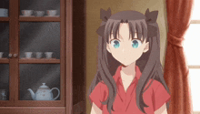 a girl in a red shirt stands in front of a glass cabinet with teapots on it