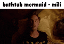 a picture of a man laying in bed with the caption bathtub mermaid mili