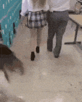 a woman in a plaid skirt is walking with a man in a white shirt