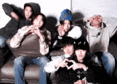 a group of young men are posing for a picture while sitting on a couch .