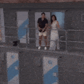 a man and a woman are standing next to each other and the man is pointing at the woman
