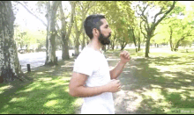 a man with a beard is jogging in a park